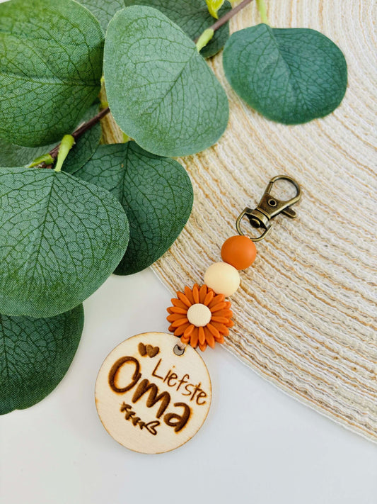 Handgemaakte sleutelhanger met houten schijfje Liefste Oma in warme herfstkleuren oranje en beige.